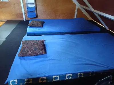 two beds in a room with blue sheets and pillows at Cabaña Vista Pinares San Ignacio Chalatenango in Chalatenango