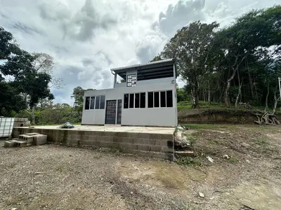 a small white building with windows on a field at Zona de Camping con casa de campo in San Salvador