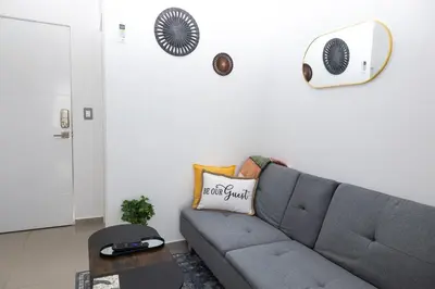 a living room with a gray couch and a fan at Casita Marsol in San Miguel in San Miguel