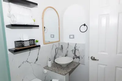 a white bathroom with a sink and a mirror at Casita Marsol in San Miguel in San Miguel