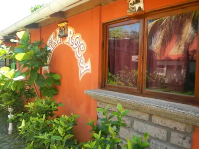 an orange house with a window and some plants at Punta Roca Surf Resort in La Libertad