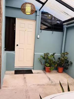 a white door on a blue house with plants at San Benito Executive Suite, luxury, security in San Salvador