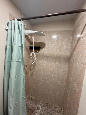 a shower with a shower curtain in a bathroom at Oasis Urbano San Benito in San Salvador