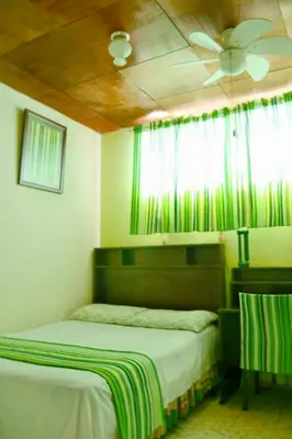 a bedroom with two beds and a ceiling fan at Hotel Oasis in San Salvador