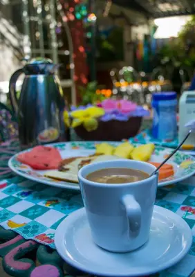 a cup of coffee on a table with plates of food at Hotel Oasis in San Salvador