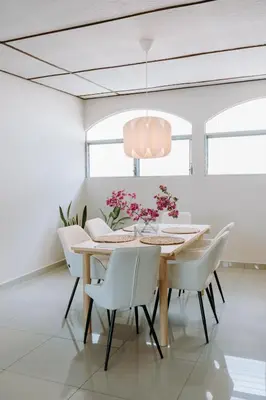 a dining room with a table and white chairs at Española - Apartamentos España in San Salvador