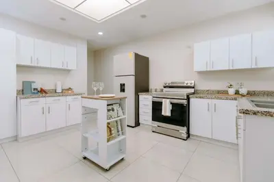 a large white kitchen with white cabinets and appliances at Española - Apartamentos España in San Salvador