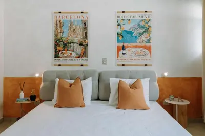a bedroom with a white bed with two posters on the wall at Española - Apartamentos España in San Salvador