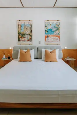 a large white bed with two orange pillows on it at Española - Apartamentos España in San Salvador