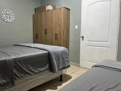 a bedroom with a bed and a wooden cabinet at Oli's apartment studio in Mexicanos