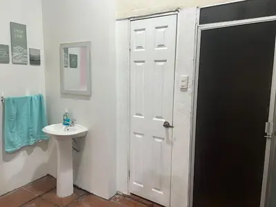 a bathroom with a white door and a sink at Oli's apartment studio in Mexicanos