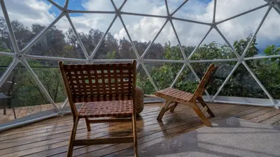 two chairs on a balcony with a glass dome at Kafen Hotel in Juayúa