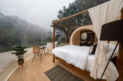 a bedroom with a canopy bed and a balcony at Kafen Hotel in Juayúa