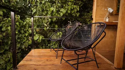 a couple of chairs sitting on a wooden deck at Kafen Hotel in Juayúa