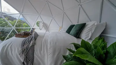 a bed in a room with a glass wall at Kafen Hotel in Juayúa