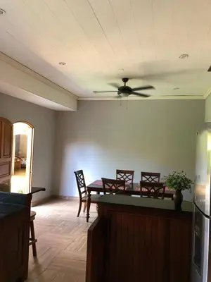 a living room with a dining table and a ceiling fan at Hostal Vega in Suchitoto