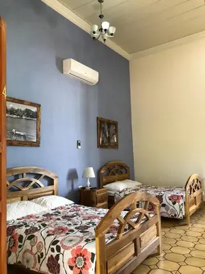 a bedroom with two beds and a ceiling fan at Hostal Vega in Suchitoto