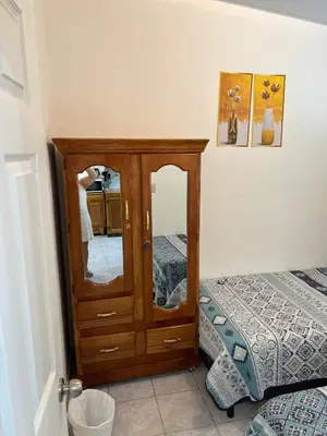 a bedroom with a dresser with a mirror next to a bed at Casa de Descanso en la Villa Panamericana in San Miguel