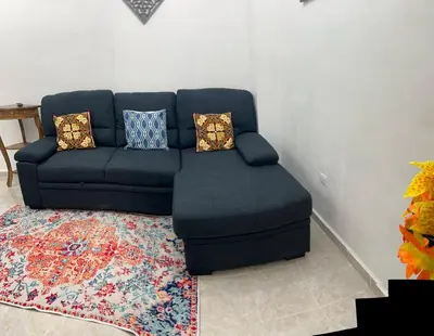a blue couch sitting in a living room with a rug at Casa de Descanso en la Villa Panamericana in San Miguel