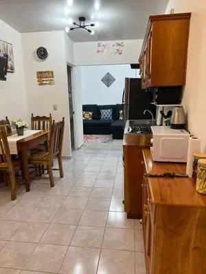 a kitchen and living room with a table and a couch at Casa de Descanso en la Villa Panamericana in San Miguel
