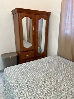 a bedroom with a bed and a dresser with a mirror at Casa de Descanso en la Villa Panamericana in San Miguel
