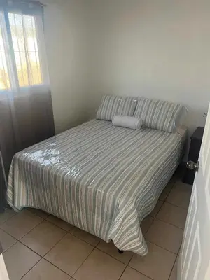 a bed with a striped comforter in a bedroom at Lovely 2BDR home in EcoTerra, Santa Ana in Santa Ana