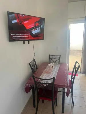 a dining room table and chairs with a tv on the wall at Lovely 2BDR home in EcoTerra, Santa Ana in Santa Ana