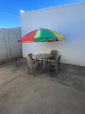 a table with chairs and a colorful umbrella at Lovely 2BDR home in EcoTerra, Santa Ana in Santa Ana