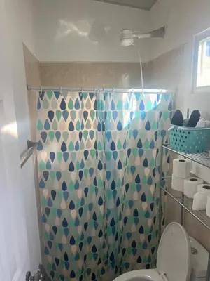 a bathroom with a shower curtain with a toilet at Lovely 2BDR home in EcoTerra, Santa Ana in Santa Ana