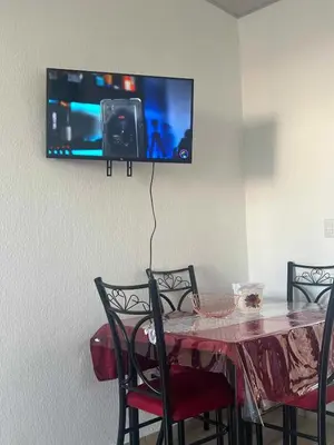 a dining room table with a tv on the wall at Lovely 2BDR home in EcoTerra, Santa Ana in Santa Ana