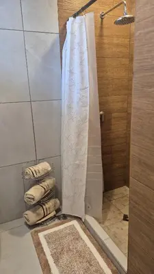 a shower with a white shower curtain in a bathroom at Stay with us just 5 minutes from the international airport of El Salvador in Las Flores