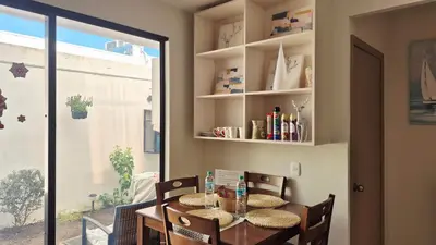 a dining room with a table and chairs and a window at Stay with us just 5 minutes from the international airport of El Salvador in Las Flores