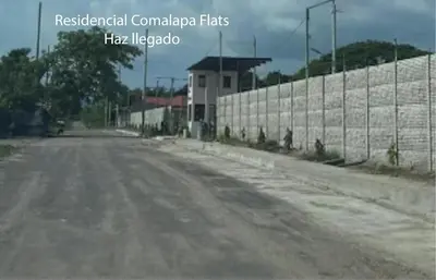 an empty road next to a brick wall at Stay with us just 5 minutes from the international airport of El Salvador in Las Flores