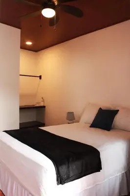 a bedroom with a large white bed with a ceiling fan at Casa Don Quijote in Concepción de Ataco