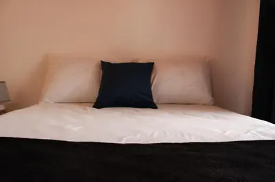 a bed with a black and white pillow on it at Casa Don Quijote in Concepción de Ataco