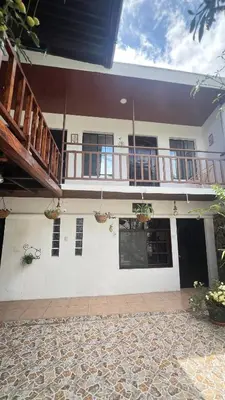 a white house with a balcony and a patio at Casa Don Quijote in Concepción de Ataco