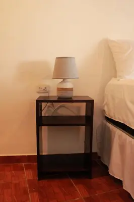 a table with a lamp on it next to a bed at Casa Don Quijote in Concepción de Ataco