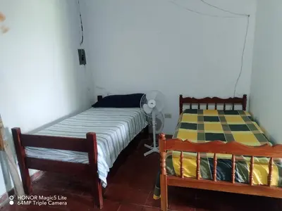 a bedroom with two beds and a fan at Casa lichis habitación basica in Suchitoto
