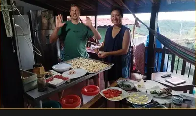 two men are standing in a kitchen preparing food at Casa lichis habitación basica in Suchitoto