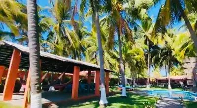 a resort with palm trees and a swimming pool at Beachfront- El Torogoz del Pimental in La Esmeralda
