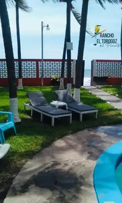 a park with benches and palm trees next to the beach at Beachfront- El Torogoz del Pimental in La Esmeralda