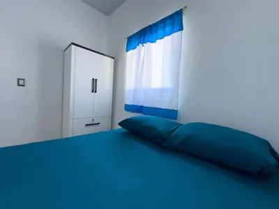 a bedroom with a blue bed and a window at Estancia El Torogoz - by Duran in Ahuachapán
