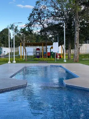 a swimming pool with blue water in a park at Estancia El Torogoz - by Duran in Ahuachapán