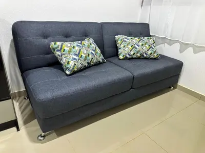 a blue couch with two pillows on it in a room at Estancia El Torogoz - by Duran in Ahuachapán