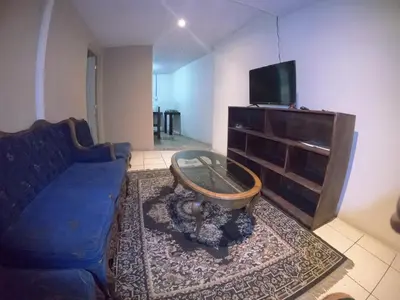 a living room with a blue couch and a tv at Apartamento económico familiar in San Salvador