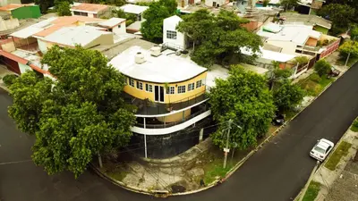 a yellow and white building on the side of a street at Apartamento económico familiar in San Salvador