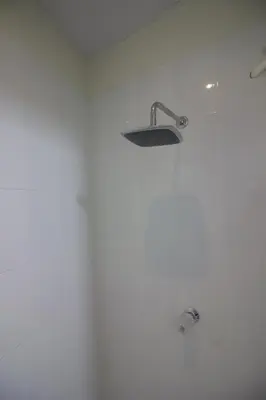 a white bathroom with a shower with a sink at Apartamento económico familiar in San Salvador