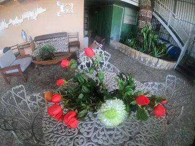 a table with red and white flowers on it at Apartamento económico familiar in San Salvador