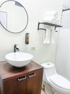 a bathroom with a sink and a mirror and a toilet at Tres Cielos Cabañas in San Pedro Masahuat