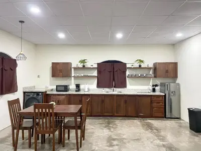a kitchen with wooden cabinets and a table and chairs at Tres Cielos Cabañas in San Pedro Masahuat